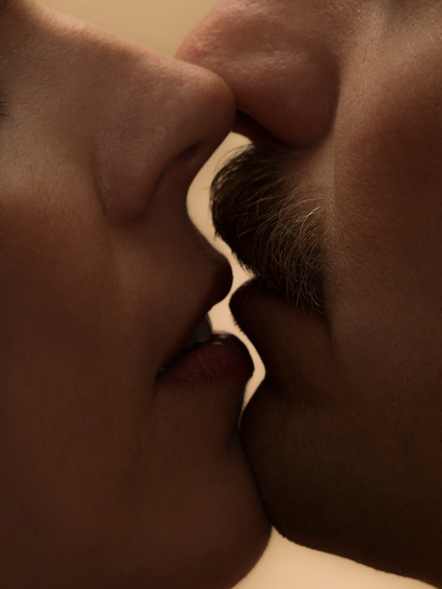 Close-up of two people with their foreheads touching, in sepia tone.